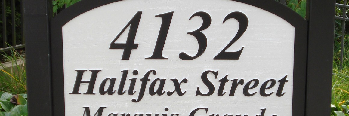 Routered, primed and painted western red cedar wood development project sign for Marquis Grande
