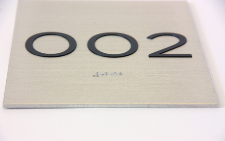 Tactile lettering and raster bead braille on brushed aluminum