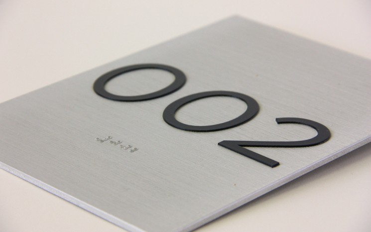 Tactile lettering and raster bead braille on brushed aluminum