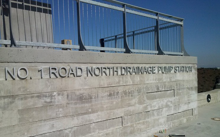 Half inch thick clear anodized aluminum letters pin mounted to concrete wall face