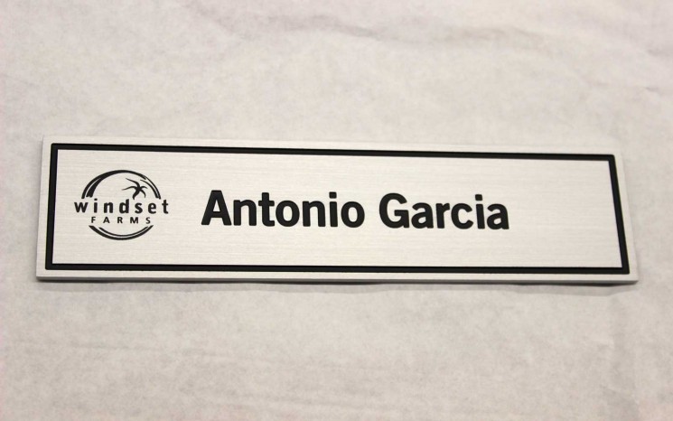 Brushed aluminum name plate with screen printed logo and rotary engraved, infilled border and name